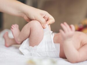 Cacca neonati: una mamma cambia il pannolino al suo neonato