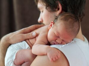 Sonno del neonato: un neonato in braccio al suo papà