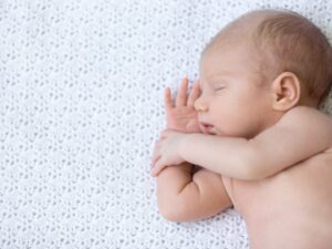 Il sonno dei bambini: un neonato dorme disteso su materasso