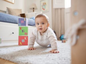 L'esplorazione della realtà circostante: un bambino gattona per casa osservando ciò che lo circonda