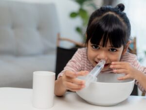 Una bambina fa i suoi lavaggi nasali