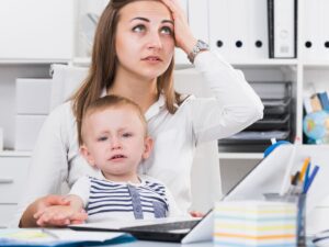 Il sonno dei bambini che non va bene: una mamma dall'aria perplessa tiene in braccio il proprio bimbo